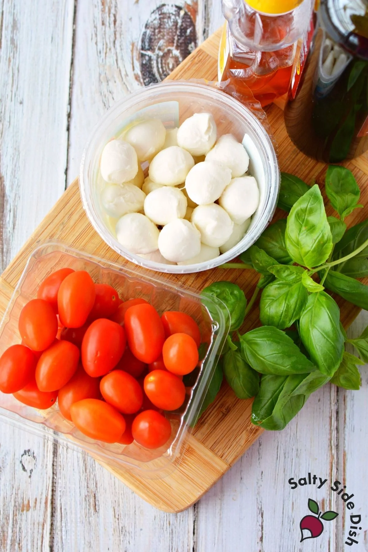 tomatoes, mozzarella and basil on a cutting board.