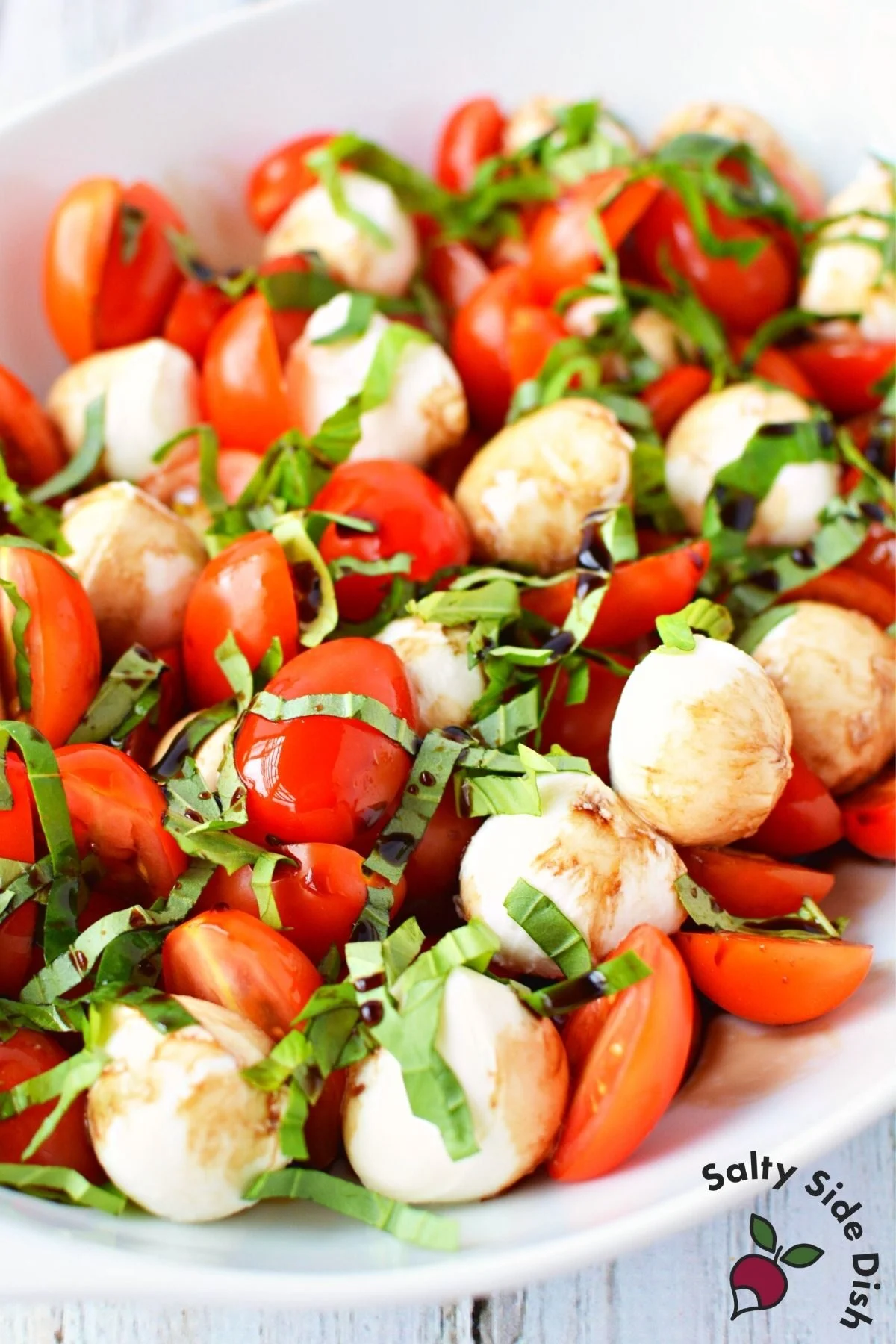 bowl of cherry tomatoes, mozzarella and basil to make caprese salad.