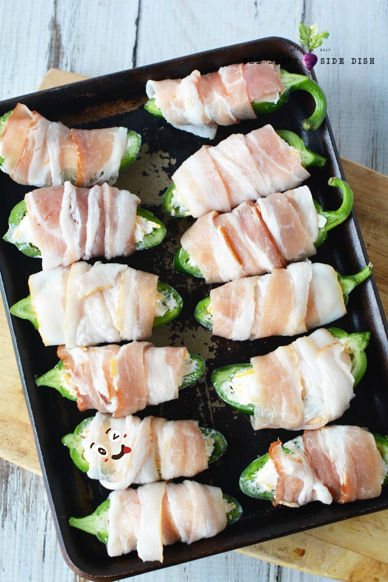 bacon wrapped jalapenos on a tray for a party