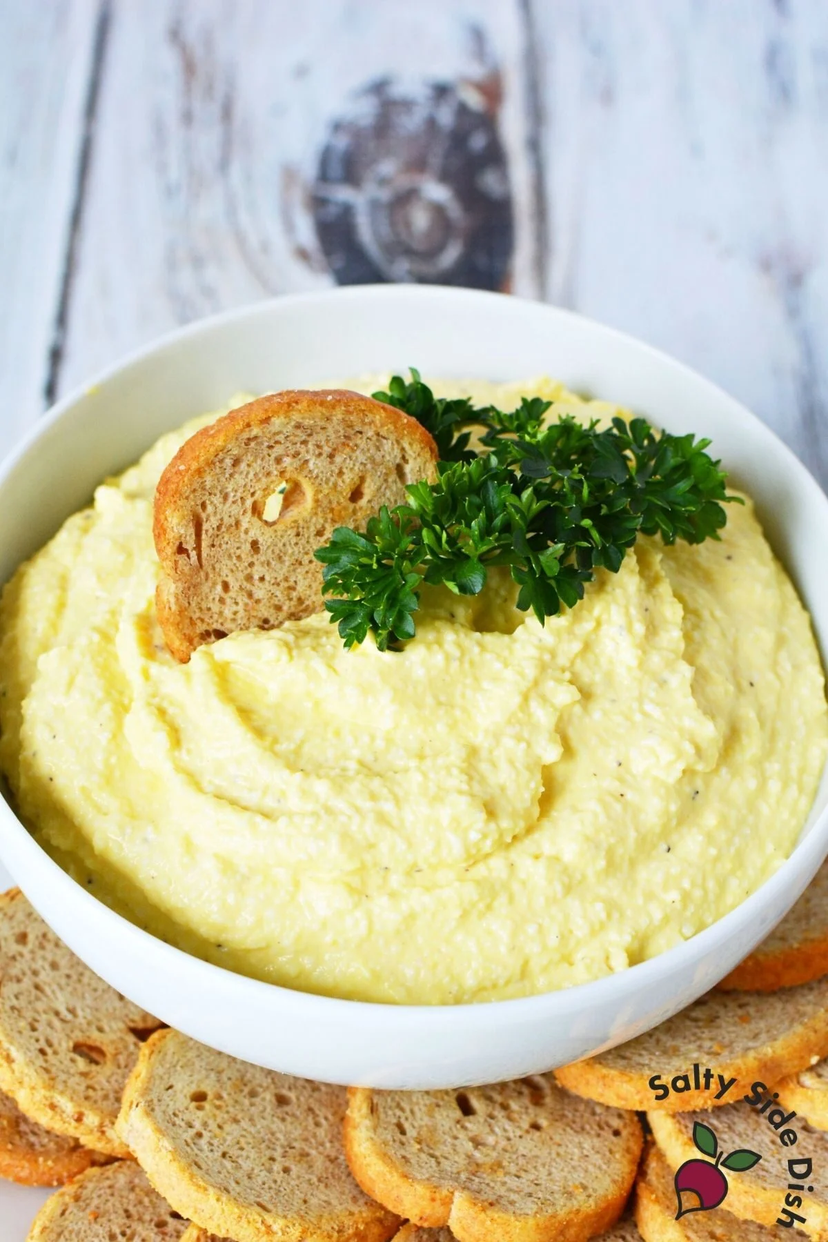 bowl of deviled egg dip with melba toast.