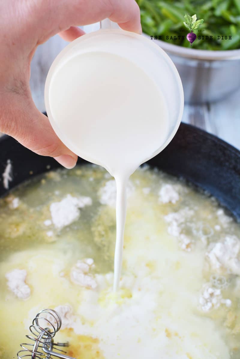 how to make green bean casserole - to start, pour in cream into cast iron pan