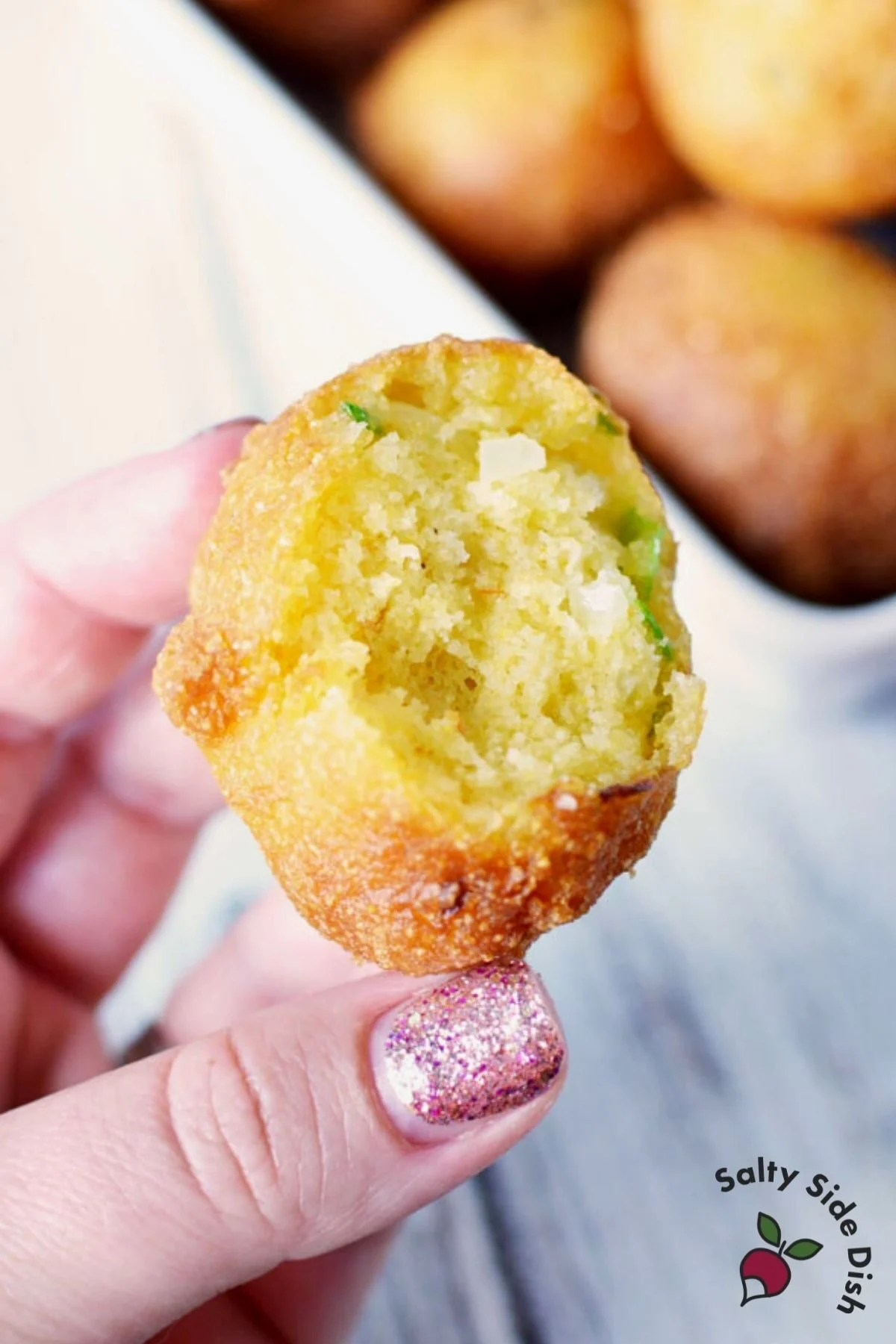 bitten hush puppies with soft center and a bit of green onion showing.