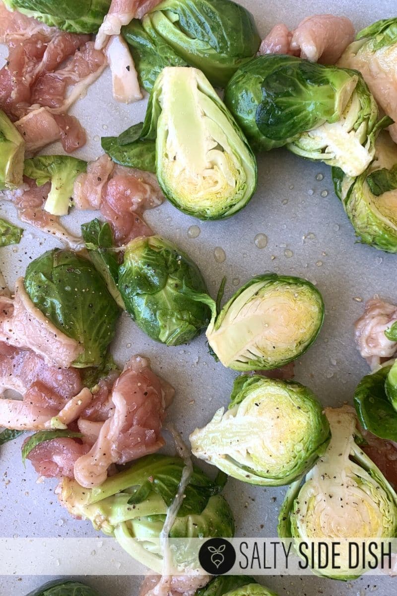 brussels sprouts cut in half and raw, raw bacon chopped, seasoned and put on a baking sheet with parchment paper