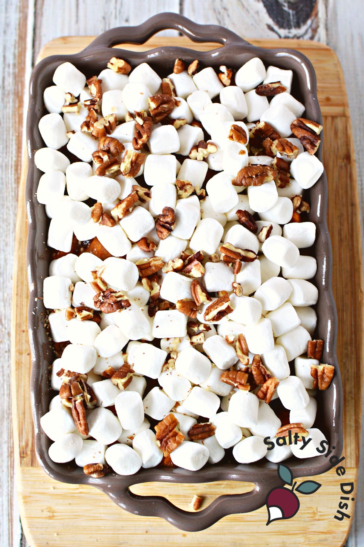 marshmallows and pecans in a baking dish ready to melt.