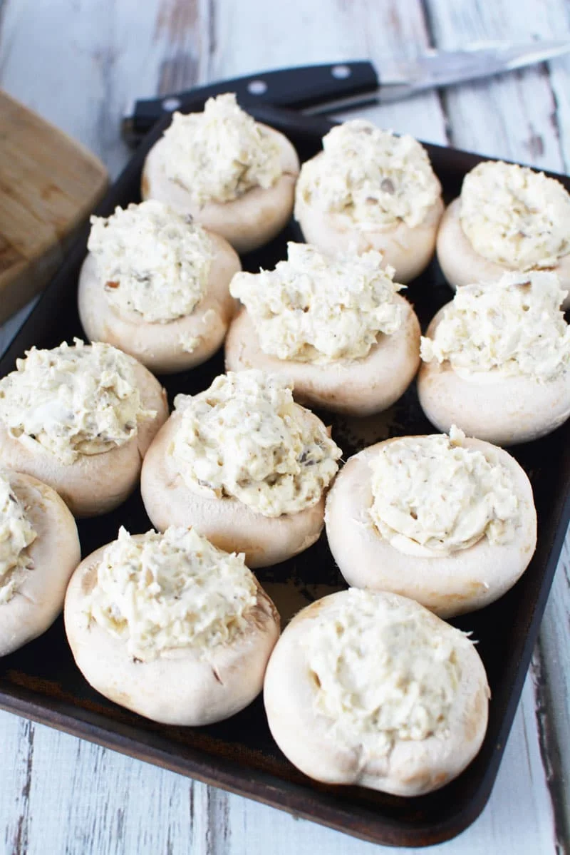 stuffed mushroom caps on a sheet pan ready to go into the oven