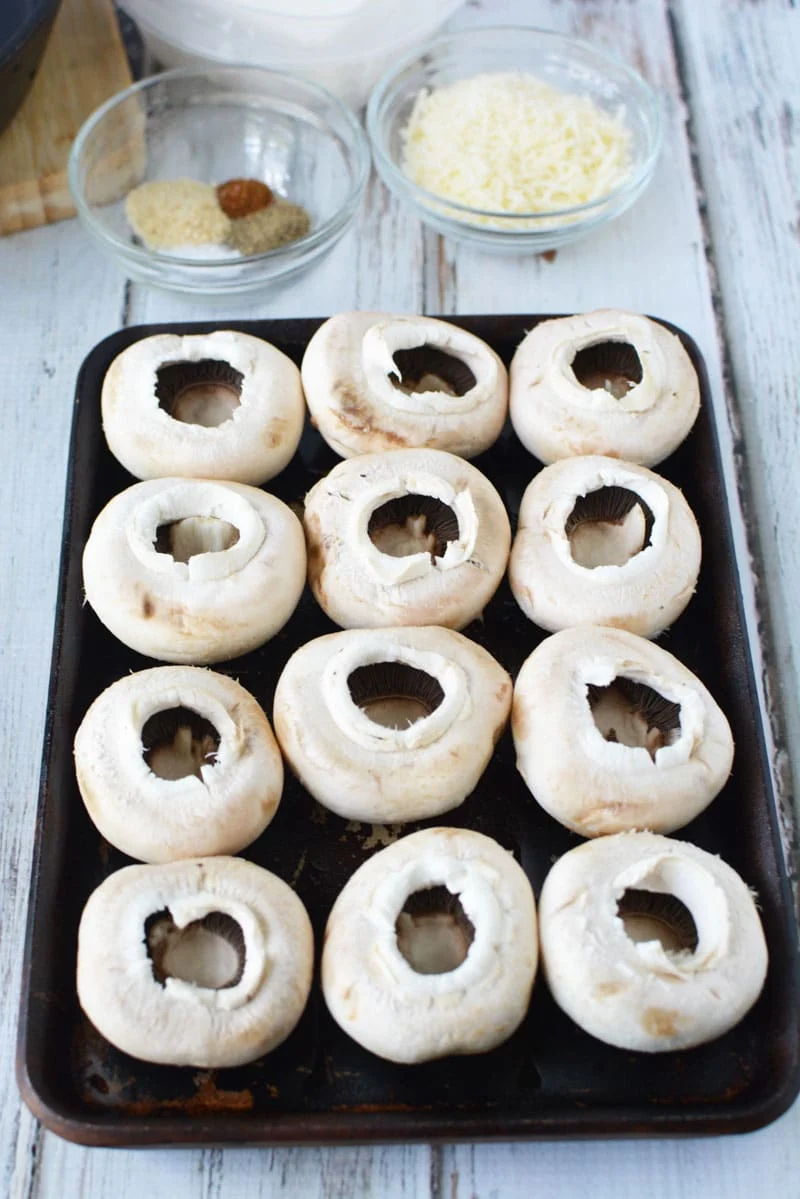 stuffed mushrooms with stems pulled out and ready for cream cheese