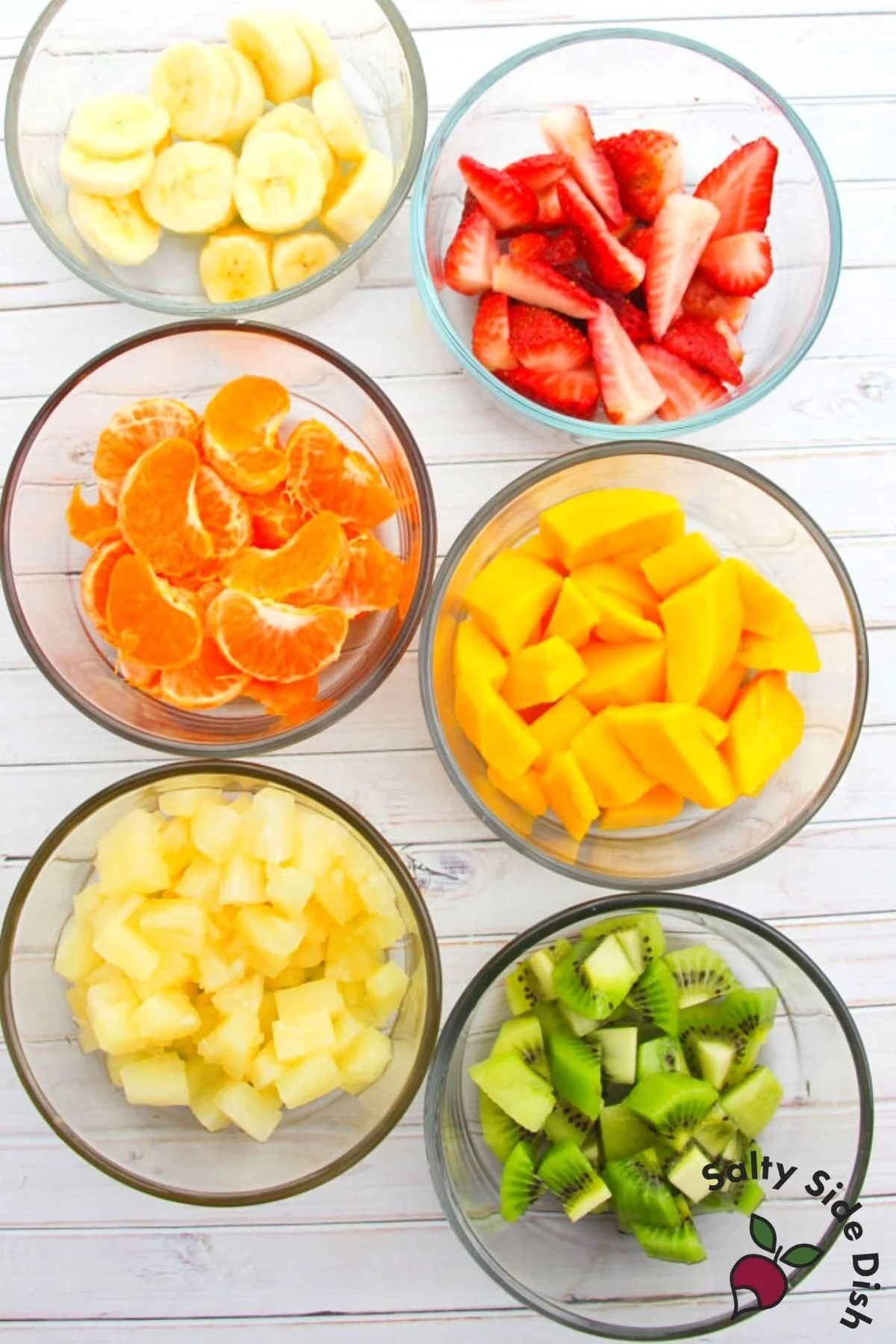 prep bowls full of fruit for fruit salad.