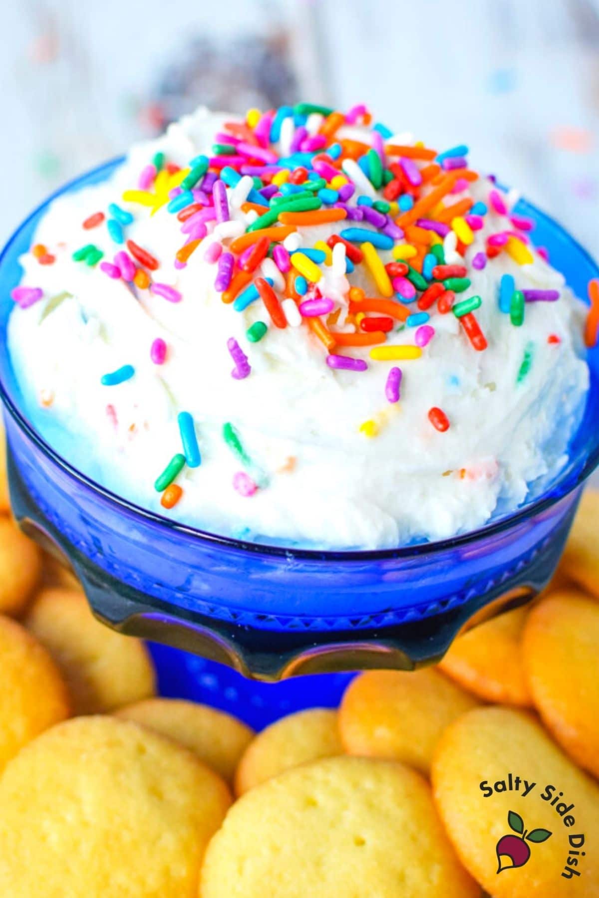 cake batter dip in a blue bowl with vanilla wafers.