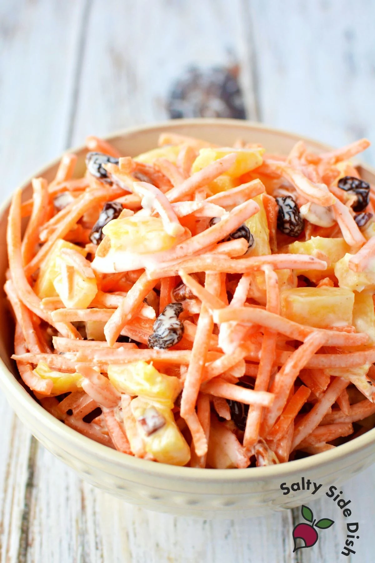 carrot raisin salad with pineapple chunks in a bowl.