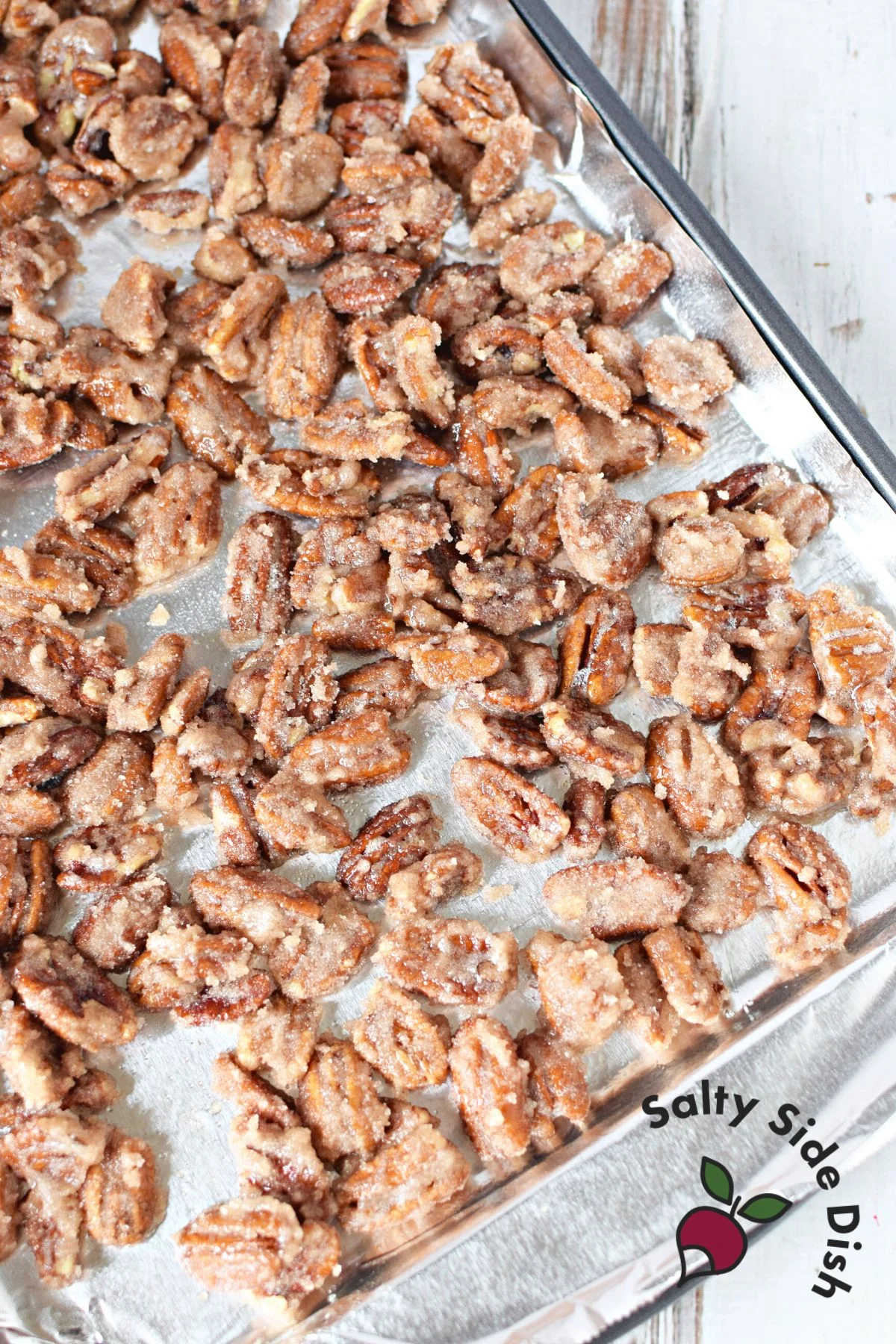 homemade sugared pecans with cinnamon sugar laying out to try on baking sheet.