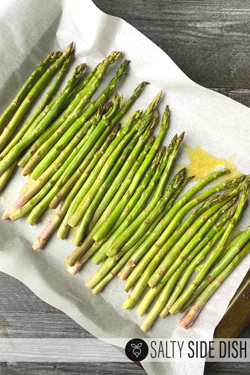oven roasted garlic asparagus on parchment paper and baking sheet