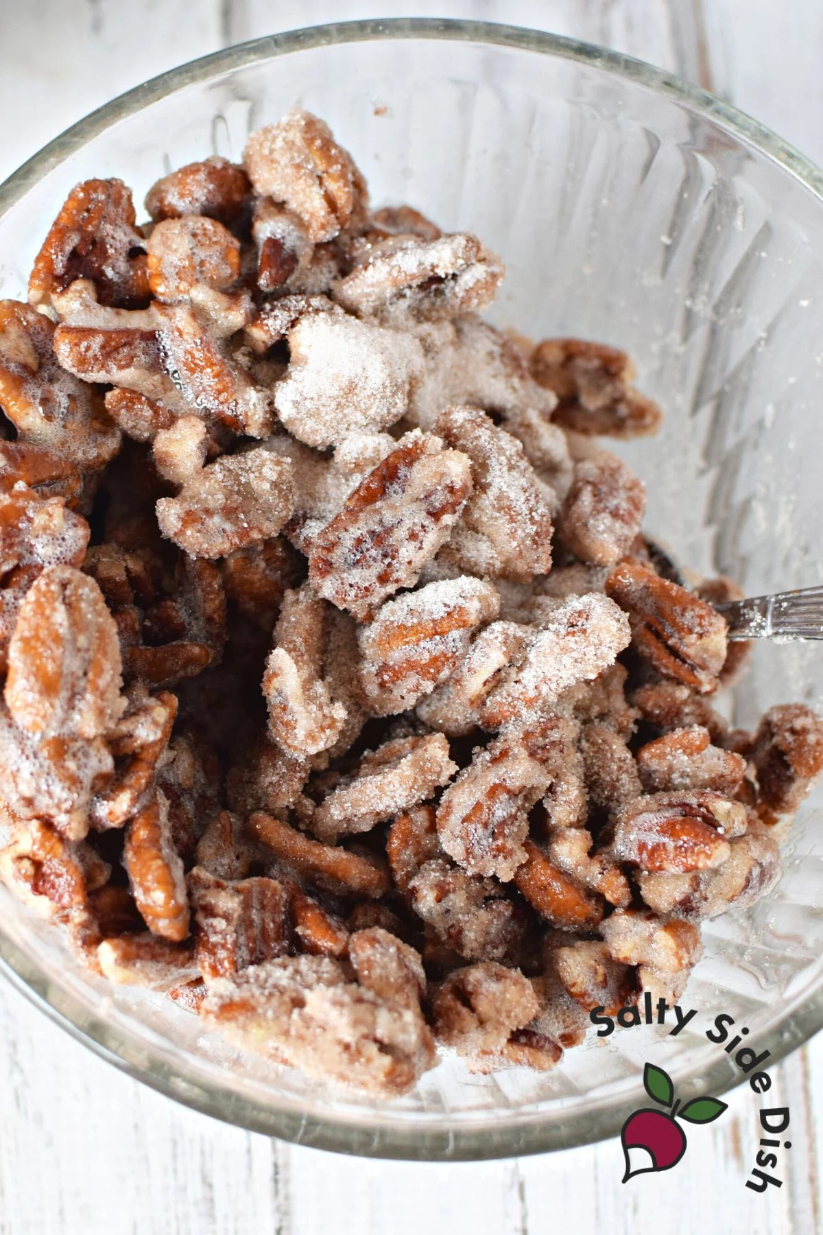 pecans being stirred into cinnamon sugar.