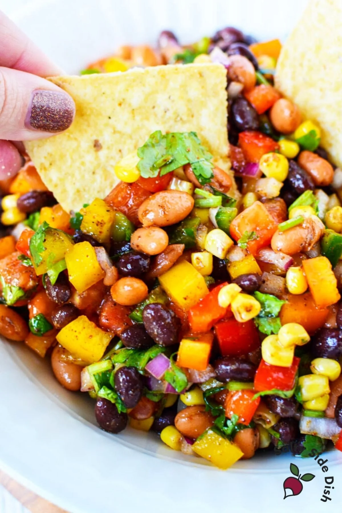 cowboy caviar recipe with chip dipping into this hearty dip.