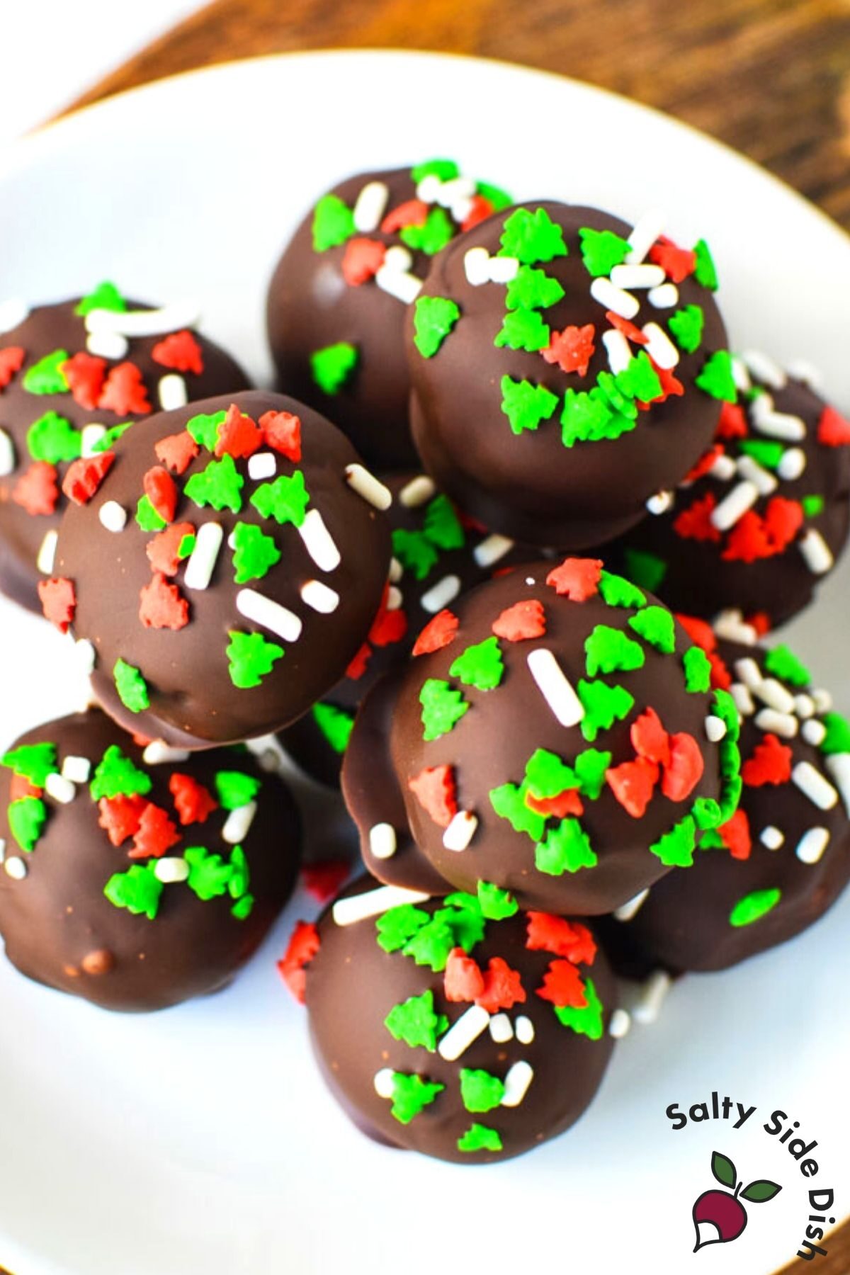 golden oreos covered in chocolate and sprinkles on a plate.