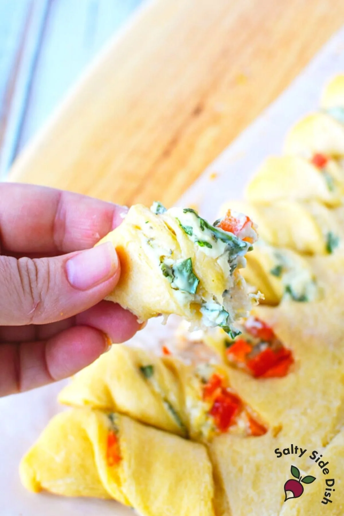 piece of bread pulled off main dough with stuffed herb cream cheese.