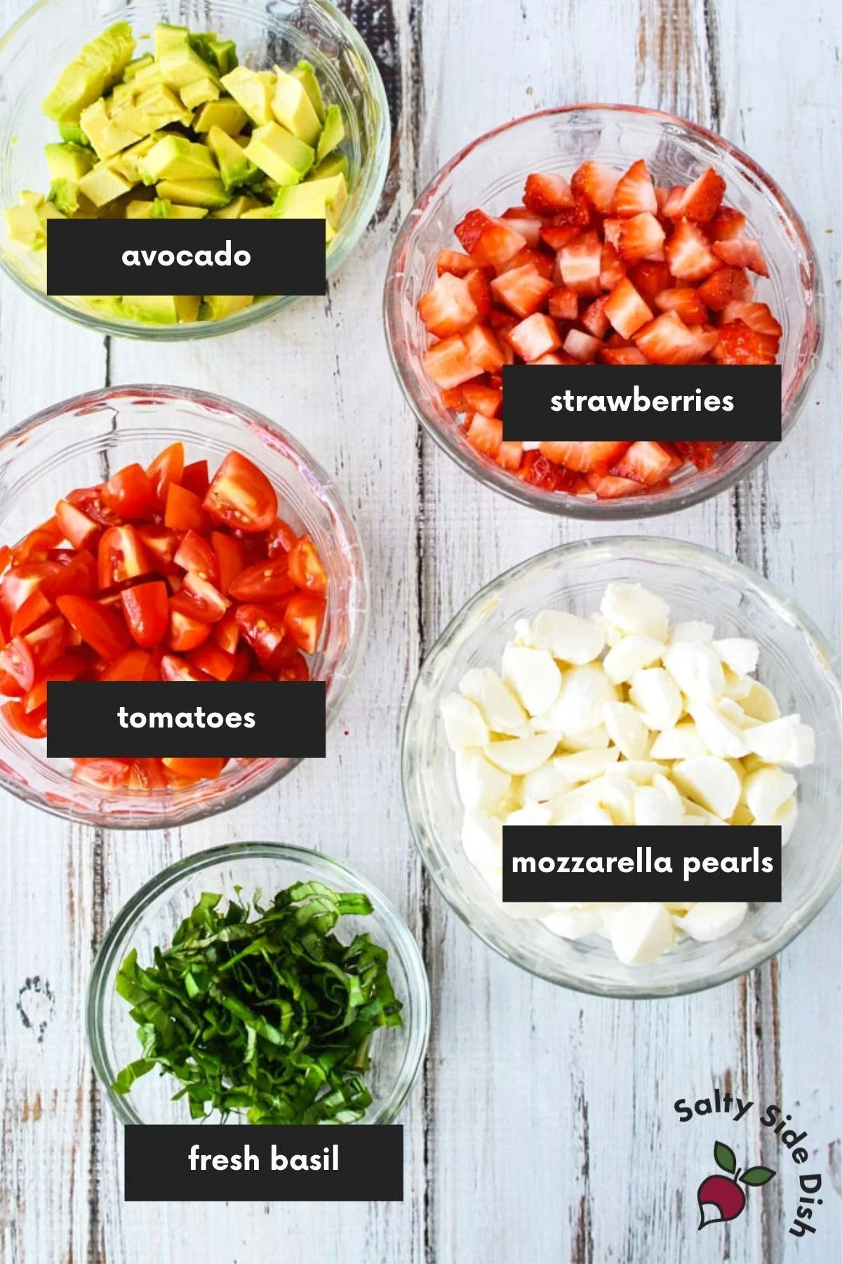 bowls of ingredients measured and cut laid out and labeled for strawberry caprese.