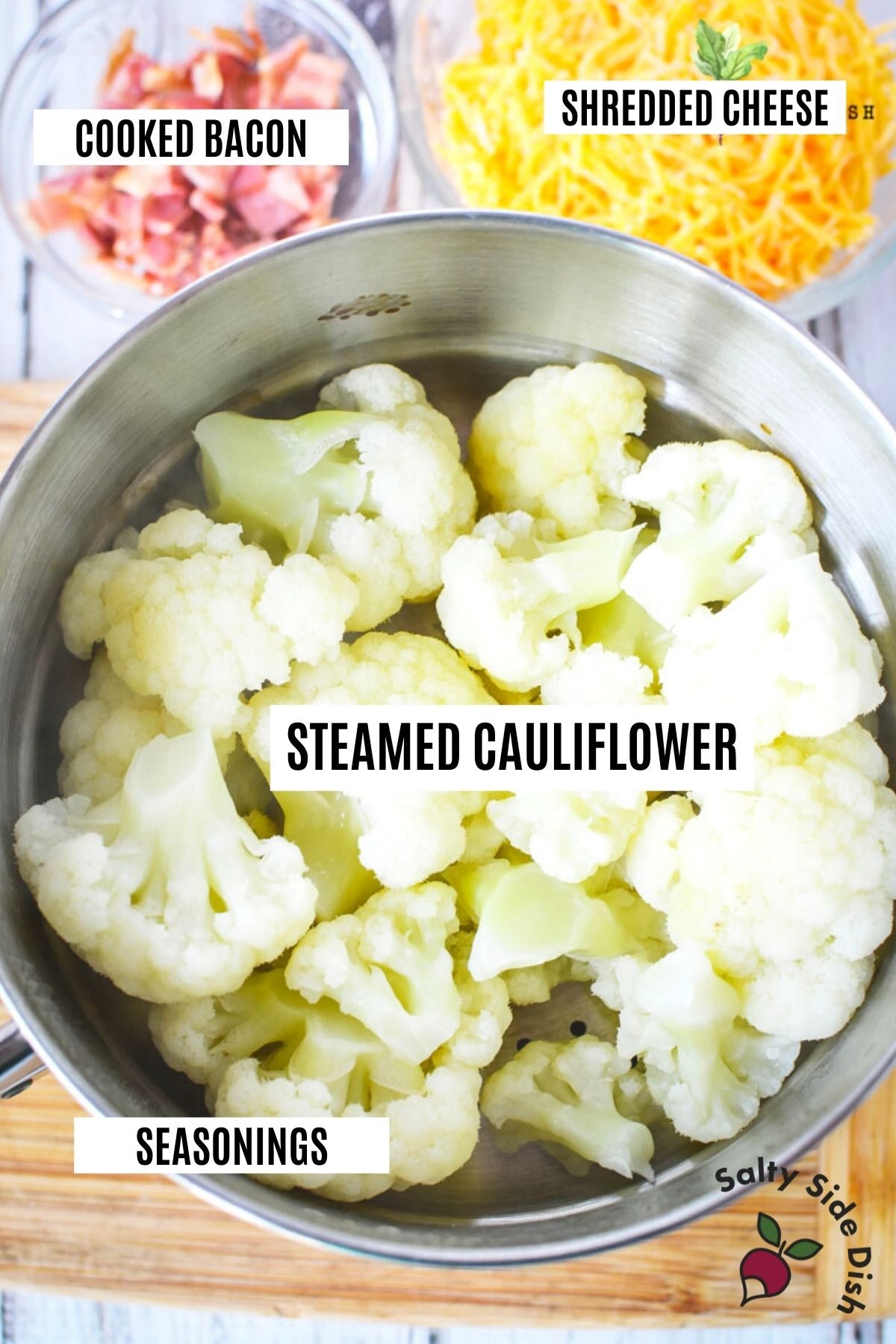 a bowl of steamed cauliflower labeled with cheese and bacon (also labeled)