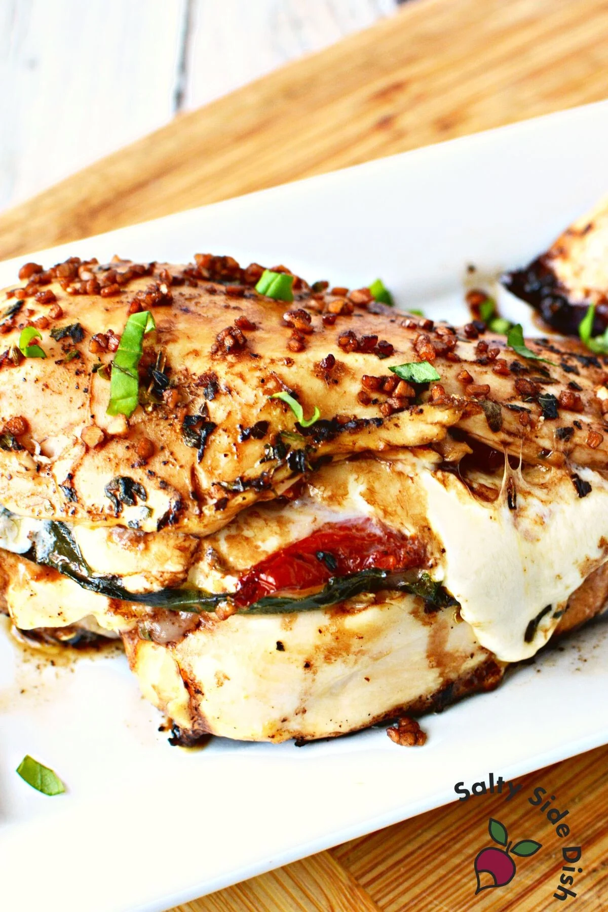 caprese stuffed chicken recipe on a white plate ready for dinner.