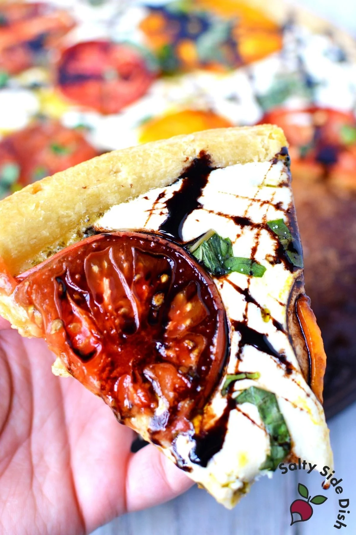slice of caprese pizza with balsamic glaze.