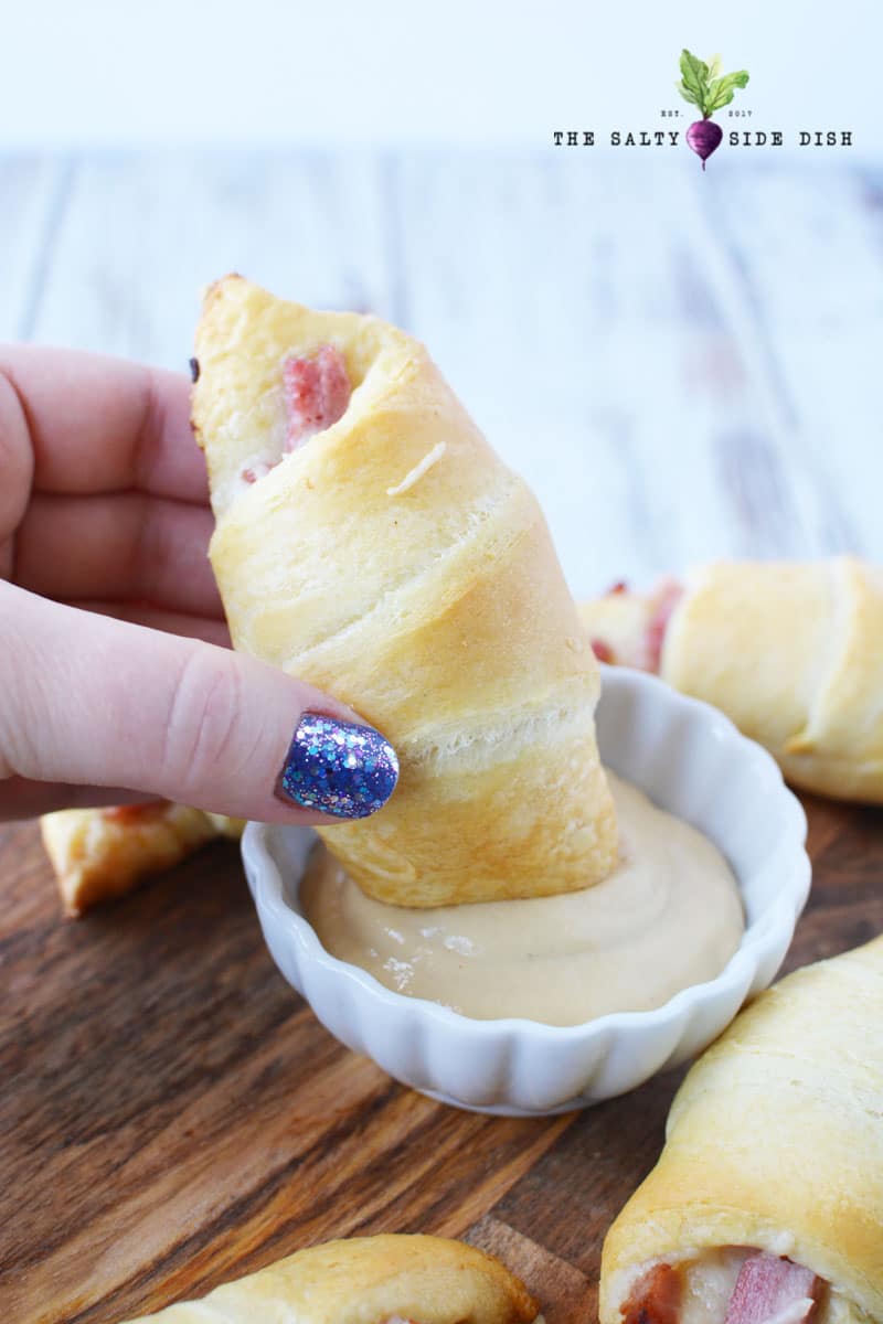 ham and cheese roll dipping in mustard sauce ready as an appetizer
