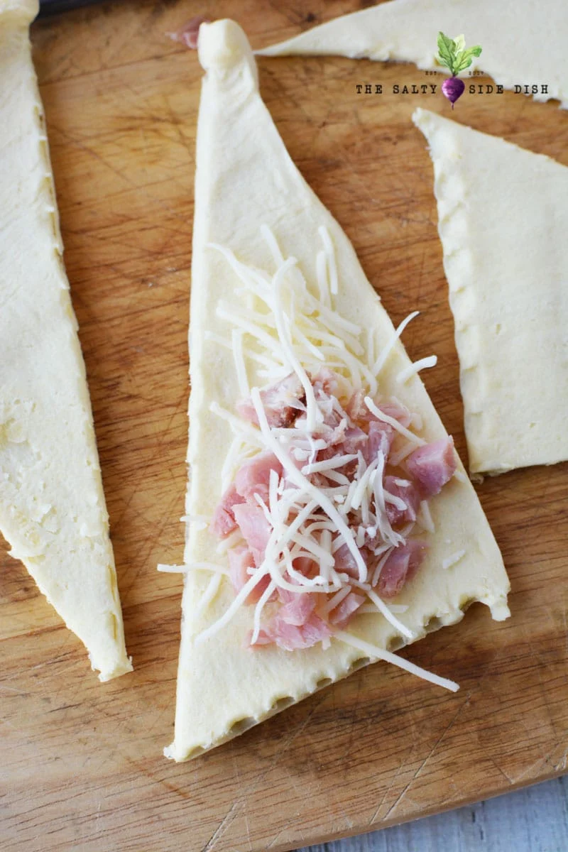 roll out your crescent roll and add diced ham and shredded cheese in your roll