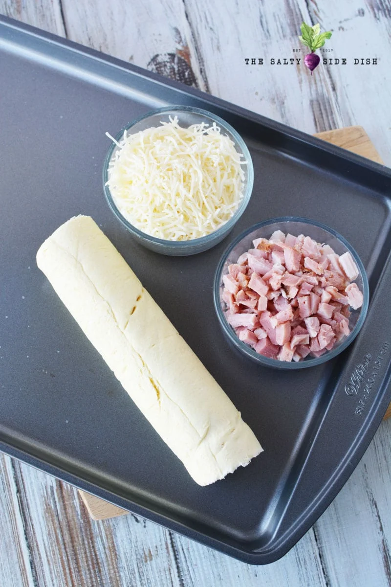 laid out rolls, cheese, and diced ham before baking