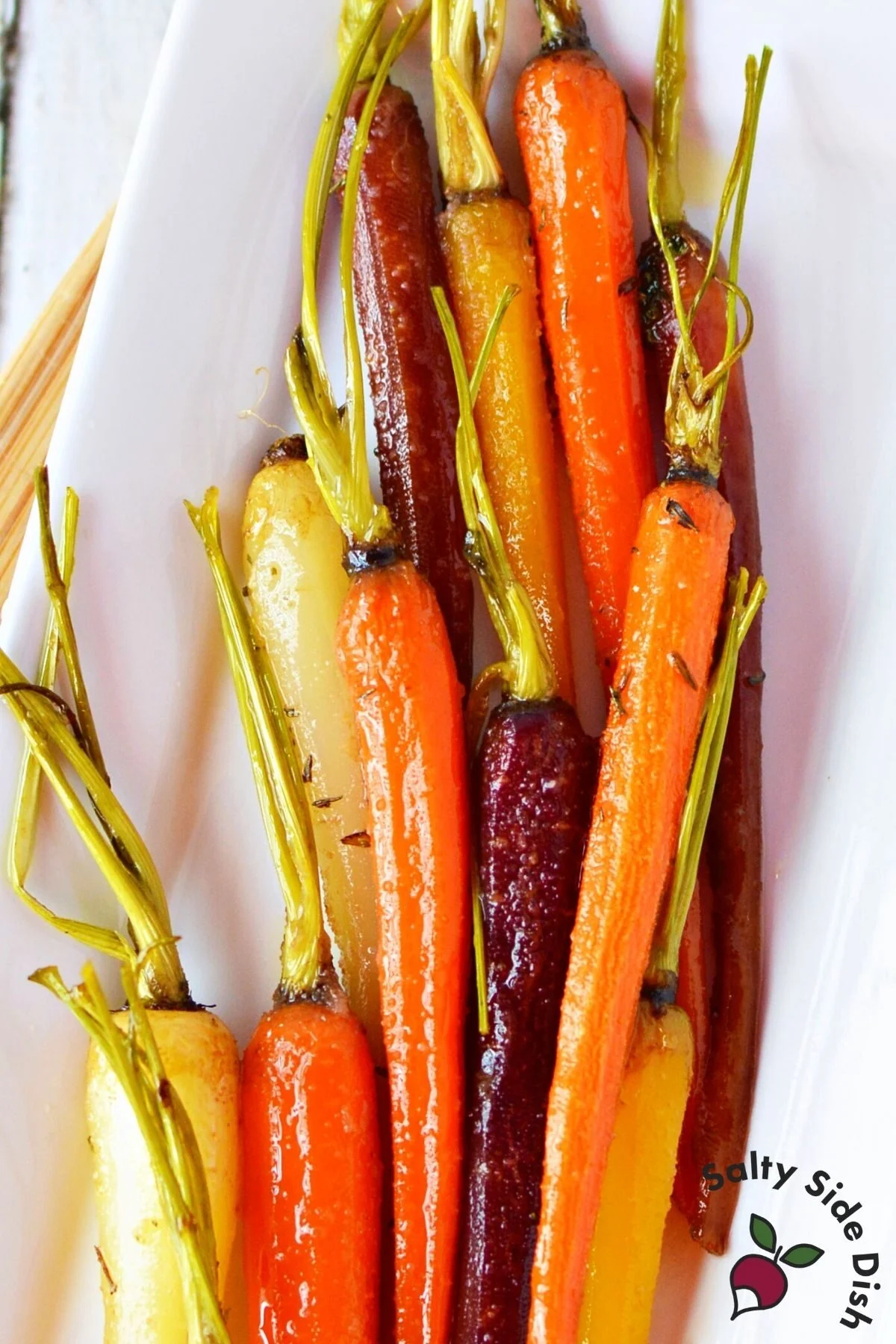 cooked carrots piled high on a white plate.