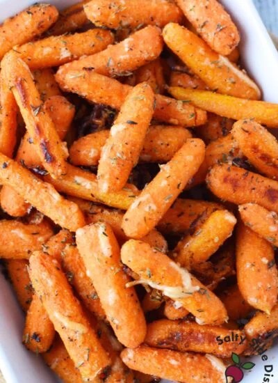 close up of parmesan roasted baby carrots showing crispy texture and melted cheese