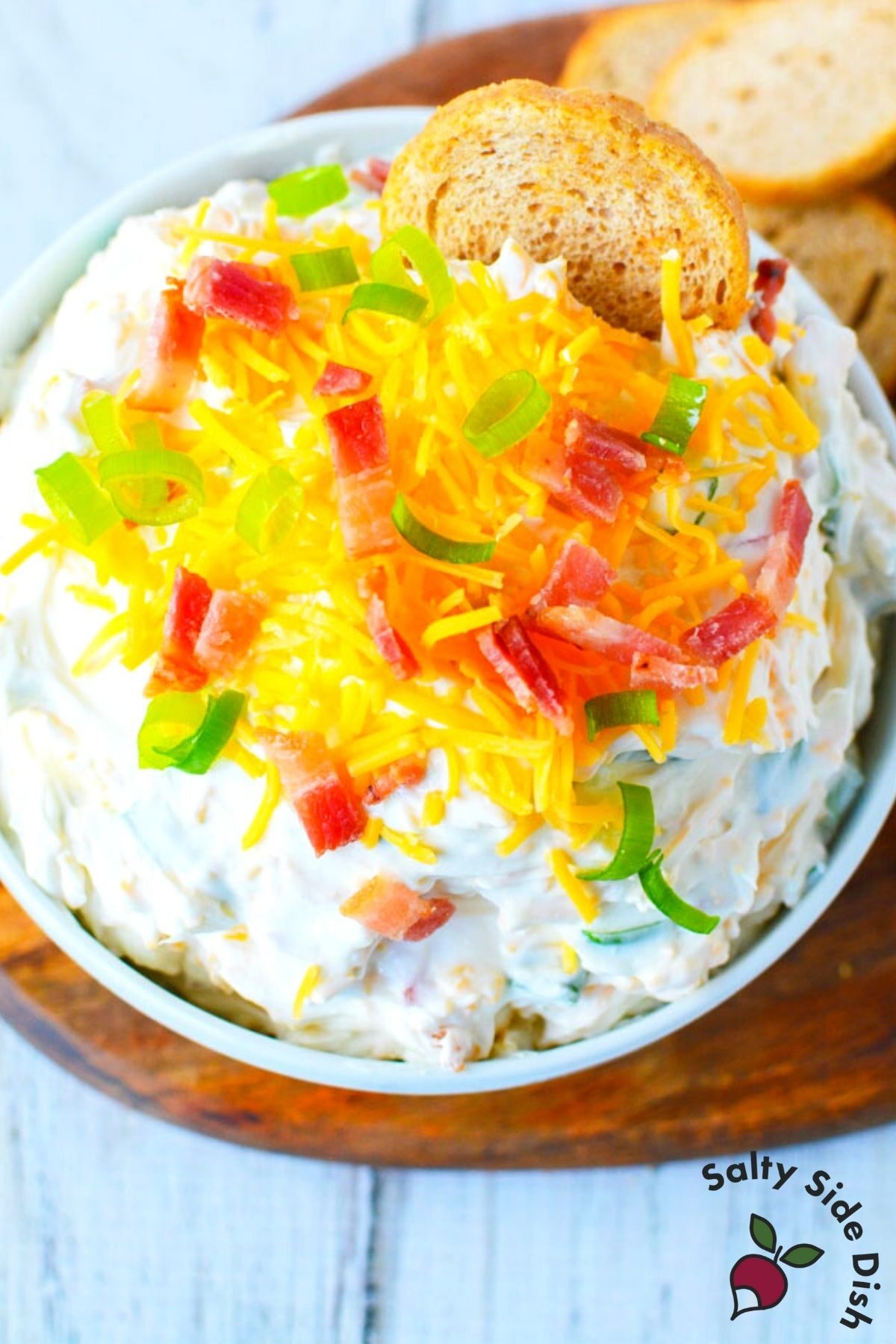 dip in a white bowl sitting on a cutting board.