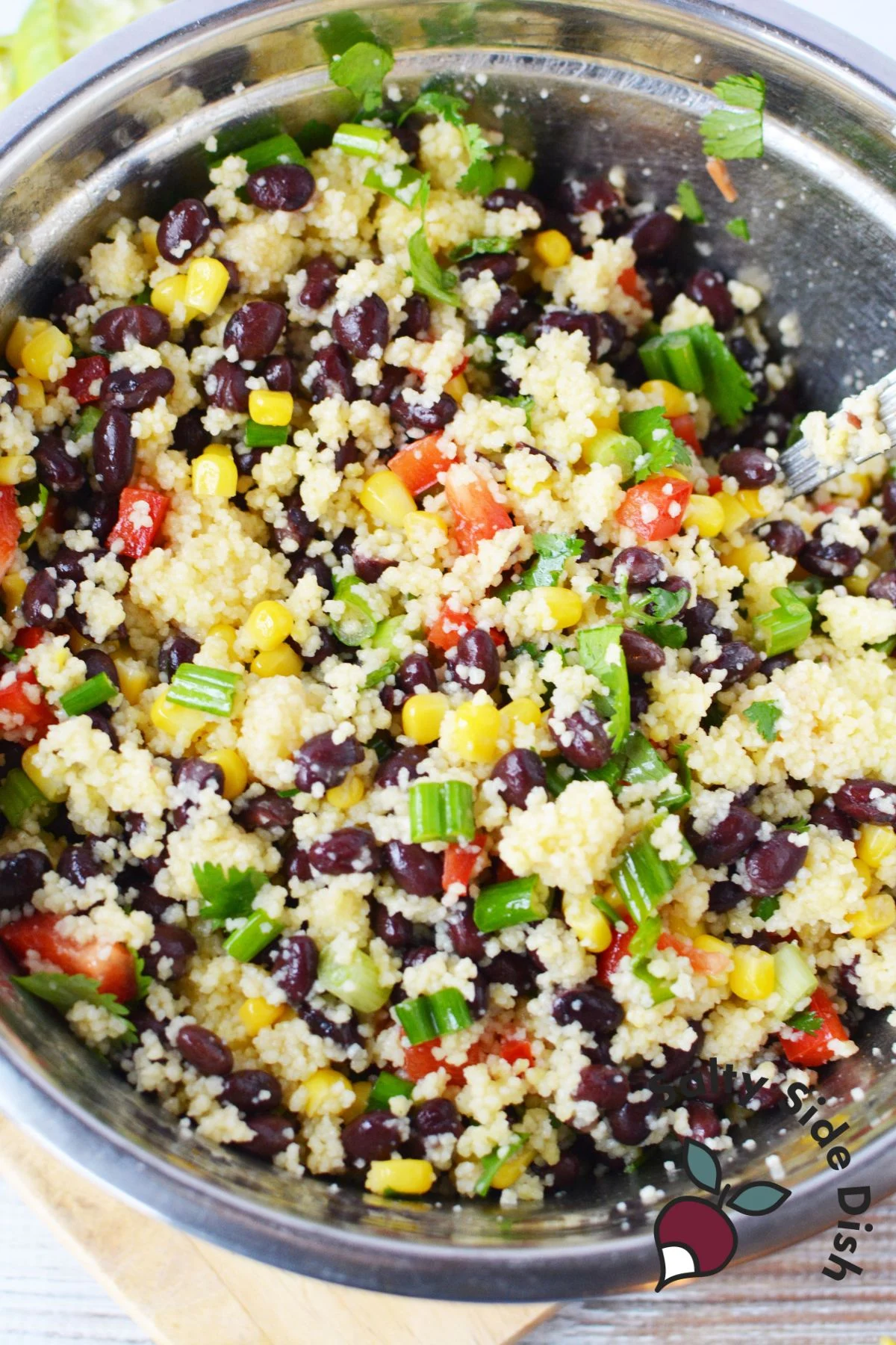 black beans, corn, peppers and couscous in a mixing bowl.