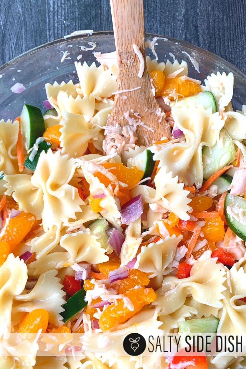 homemade potluck pasta salad with bow tie pasta, oranges, and ginger dressing.