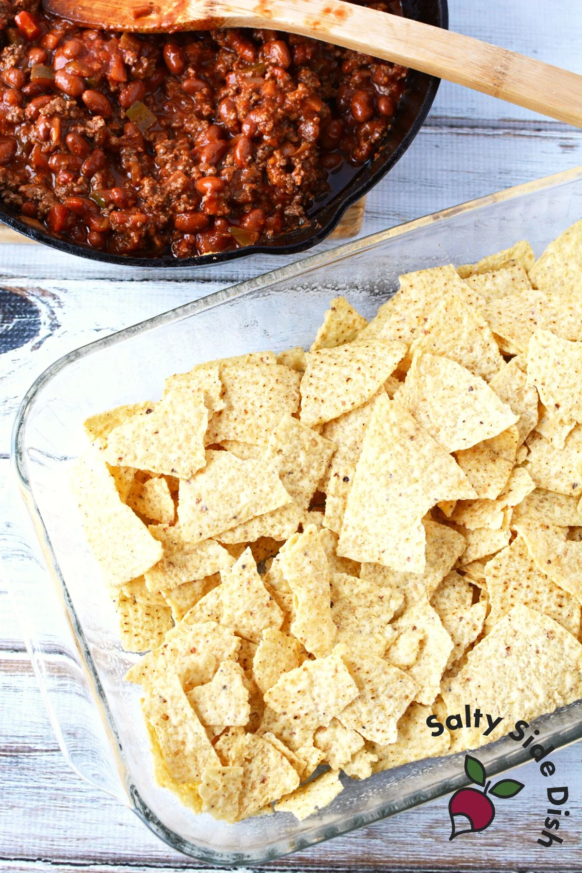 add a layer of thick tortilla chips in a baking dish.