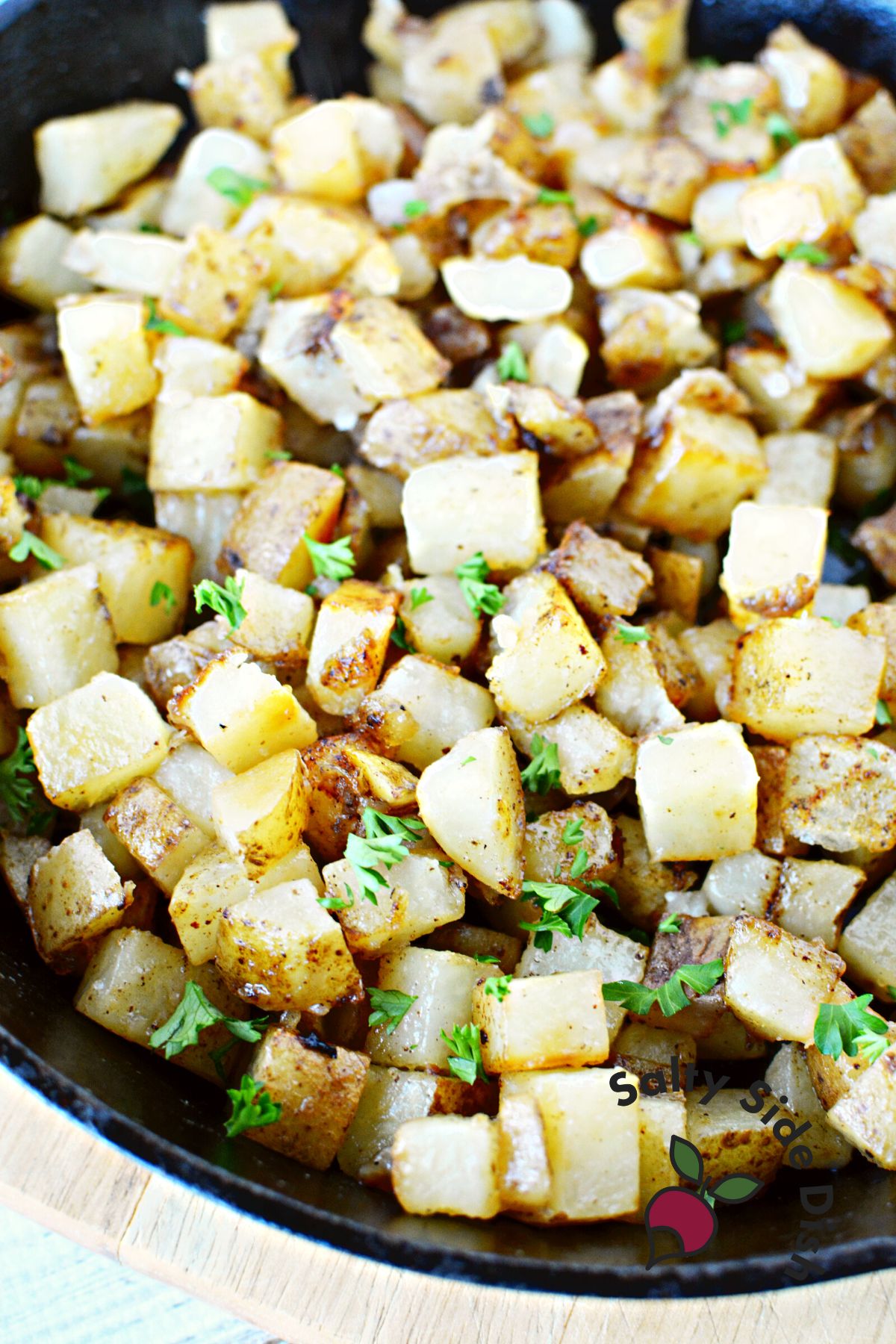 cooked cowboy potatoes in a cast iron skillet with fresh herbs.