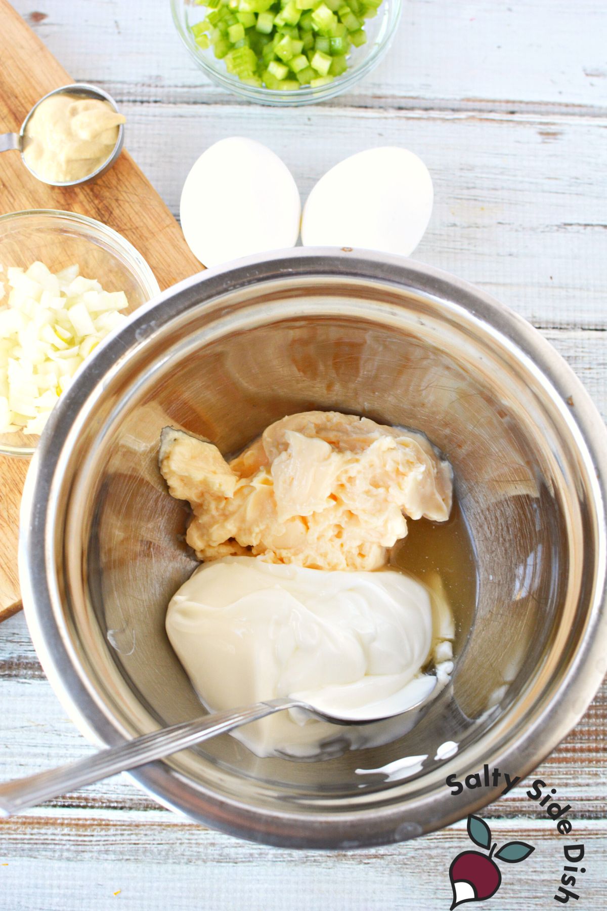 combining dill salad ingredients in a mixing bowl.