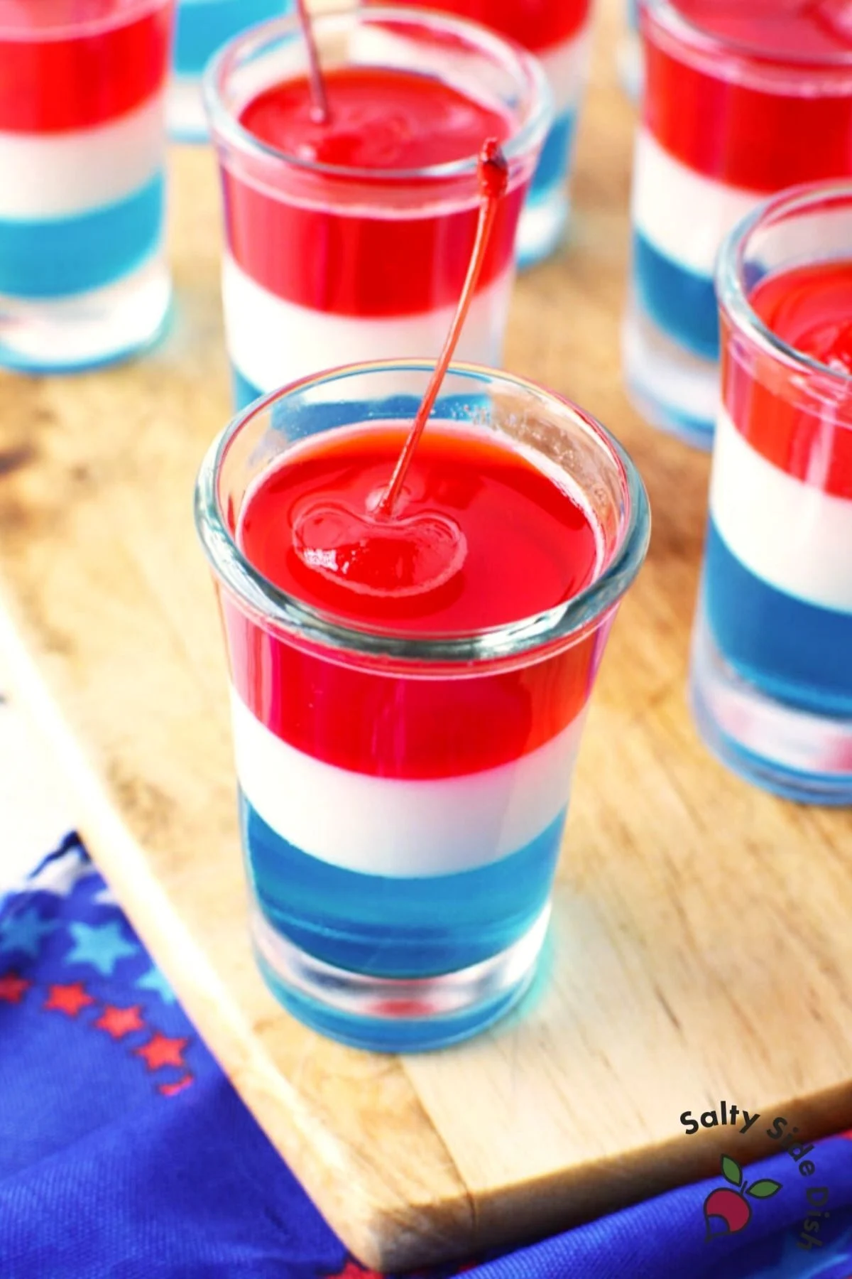a table full of layered Jell-O shots sitting on a cutting board.