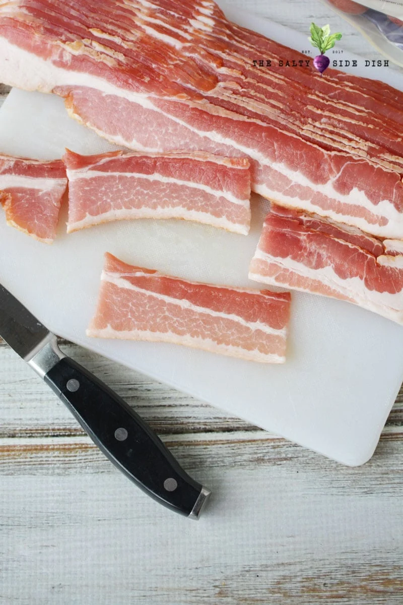 bacon cut into thirds with knife on cutting board for your baby potatoes