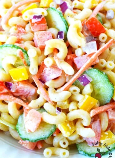 pile of cooked macaroni and fresh vegetables in a salad.