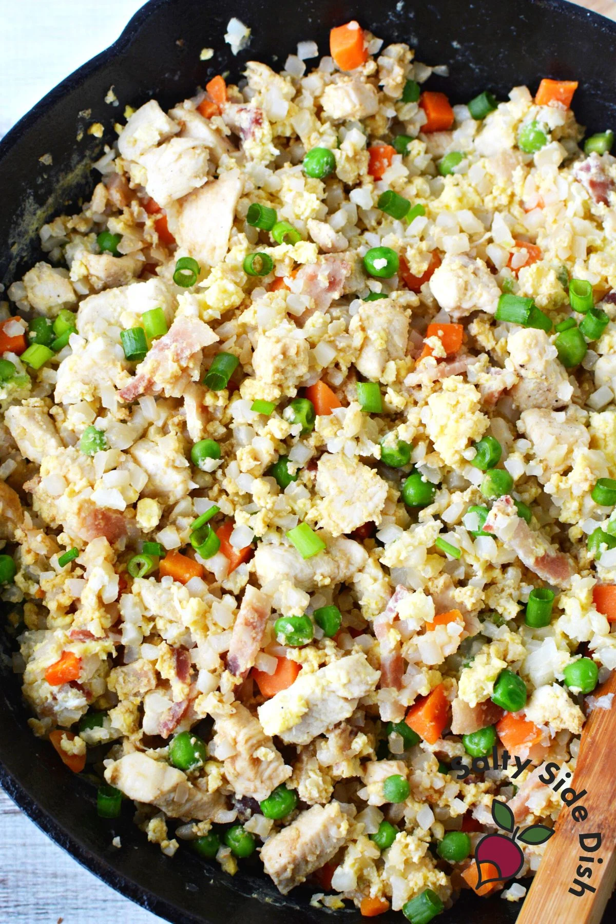 riced cauliflower soy sauce with chicken in cast iron pan.