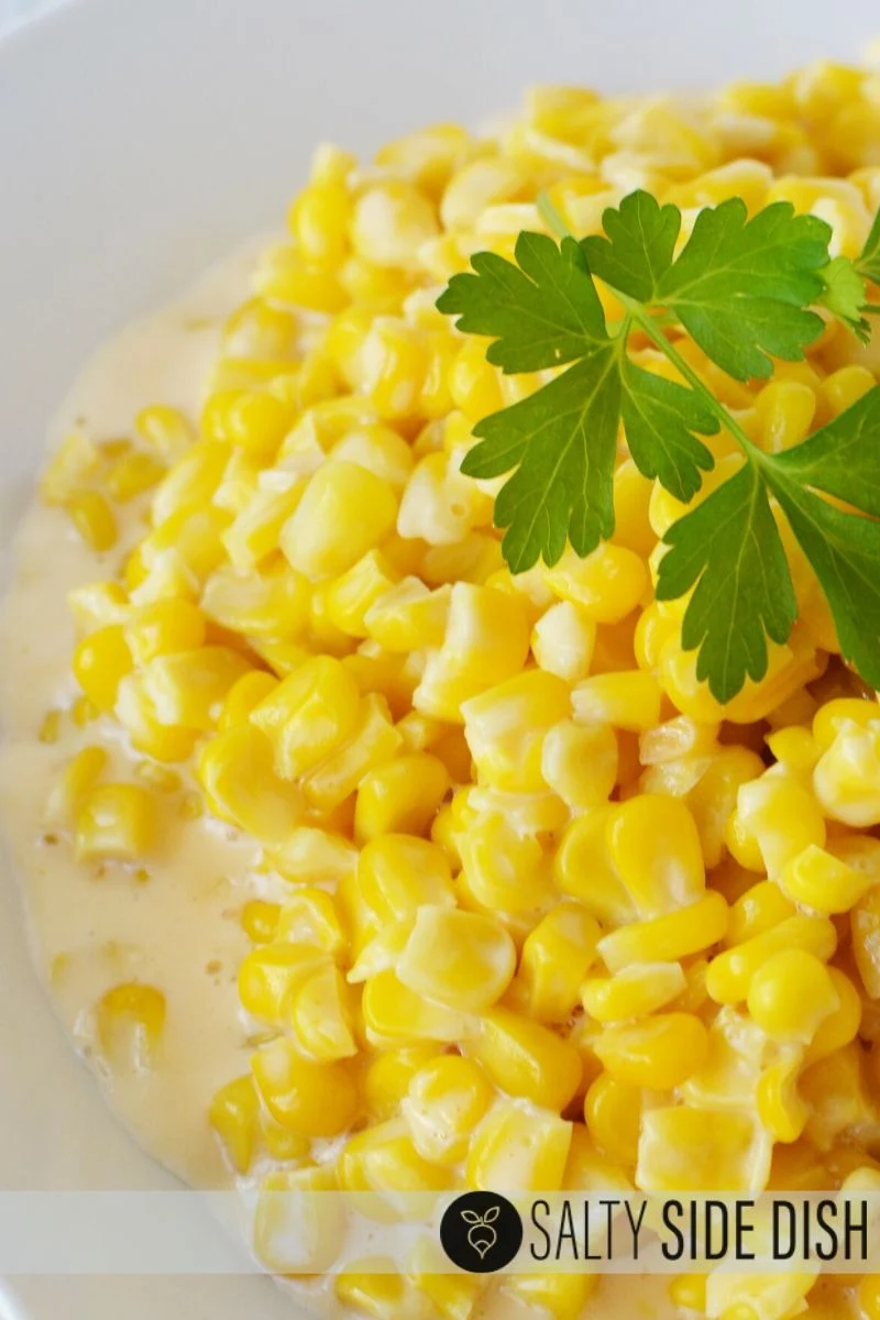 crock pot cheesy corn with parsley in a bowl