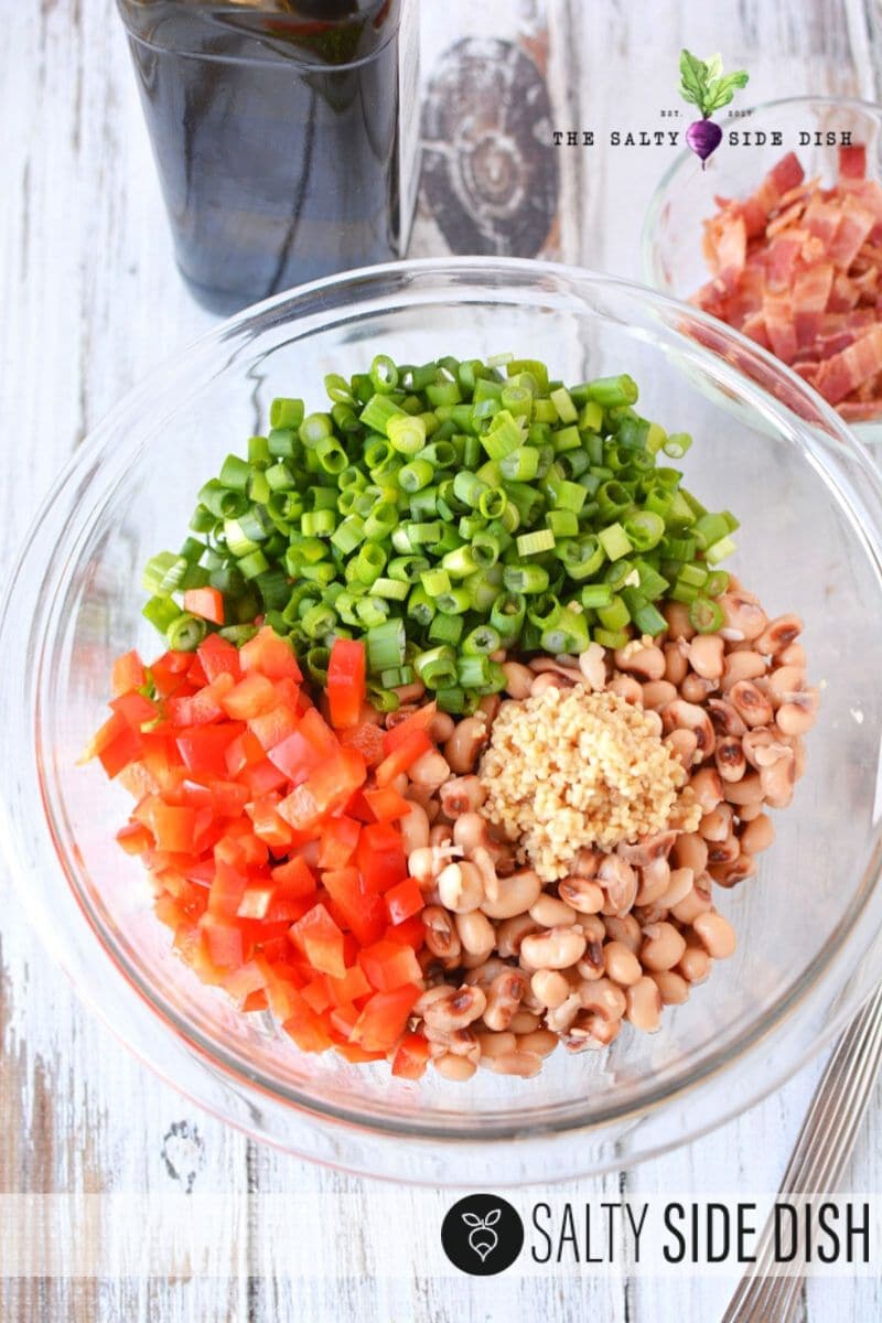 adding spice to your black eyed pea salad preparation, in glass bowls