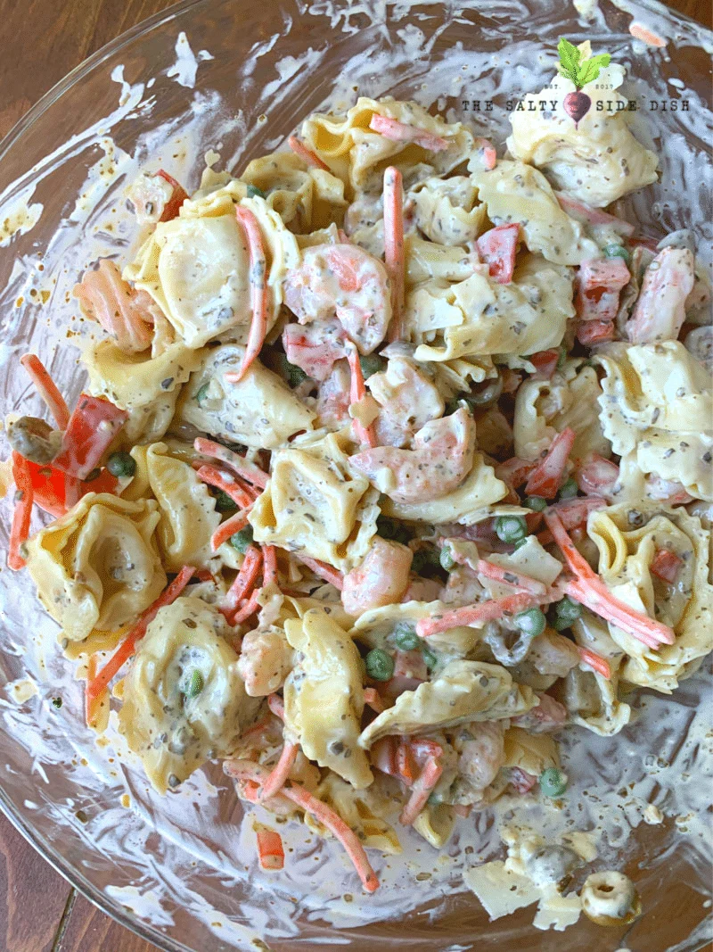pesto pasta salad with dressing in a glass bowl