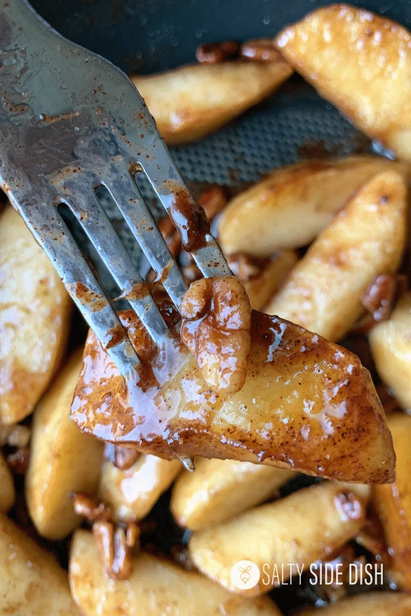 Cinnamon coated apple with a fork and a pecan on top