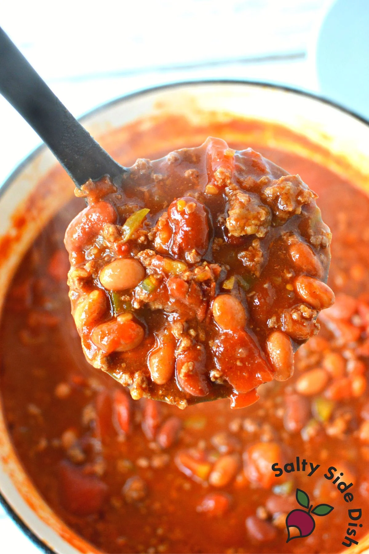 a close up of chili recipe in a ladle.