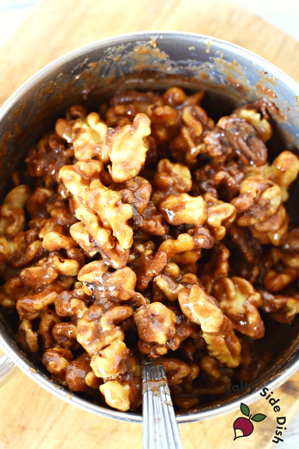 adding walnuts to sugar saucepan.