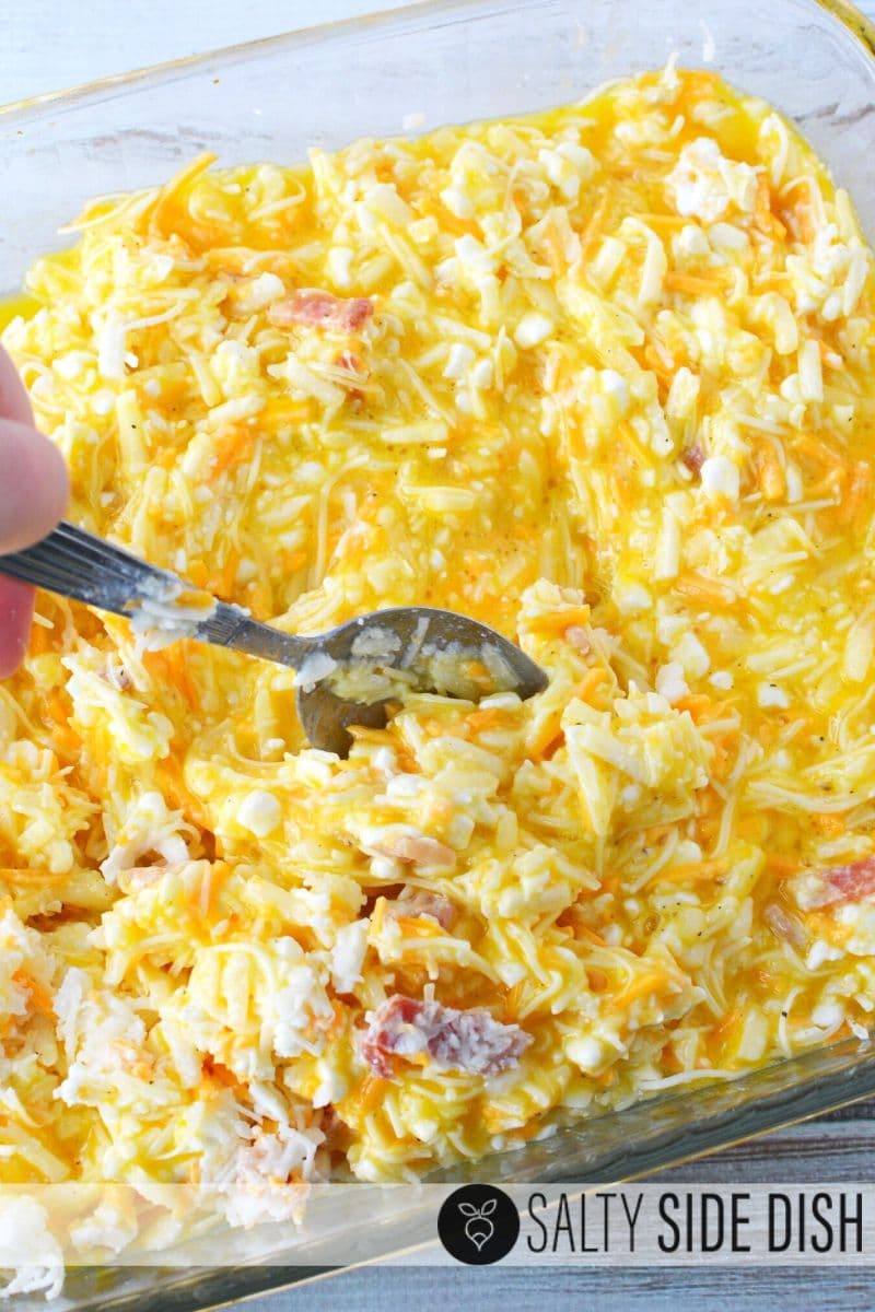 Use a spoon to mix eggs, bacon, hash browns and all the cheeses into one delicious breakfast recipe casserole