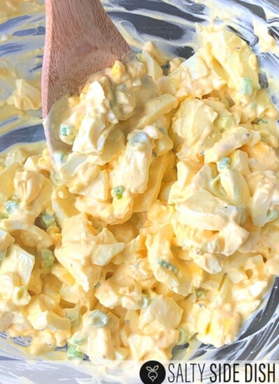 egg salad mixing in a bowl with a spoon.