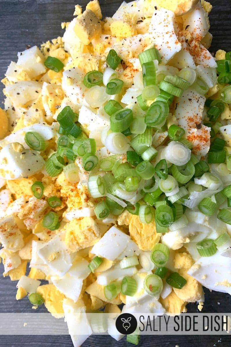 ingredients in a bowl for the best egg salad. Topping w/ sliced green onions.