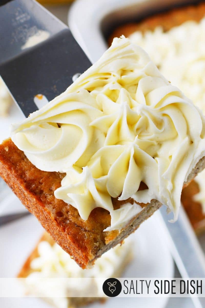 banana bread cake with cream cheese frosting on a spatula ready to serve as dessert