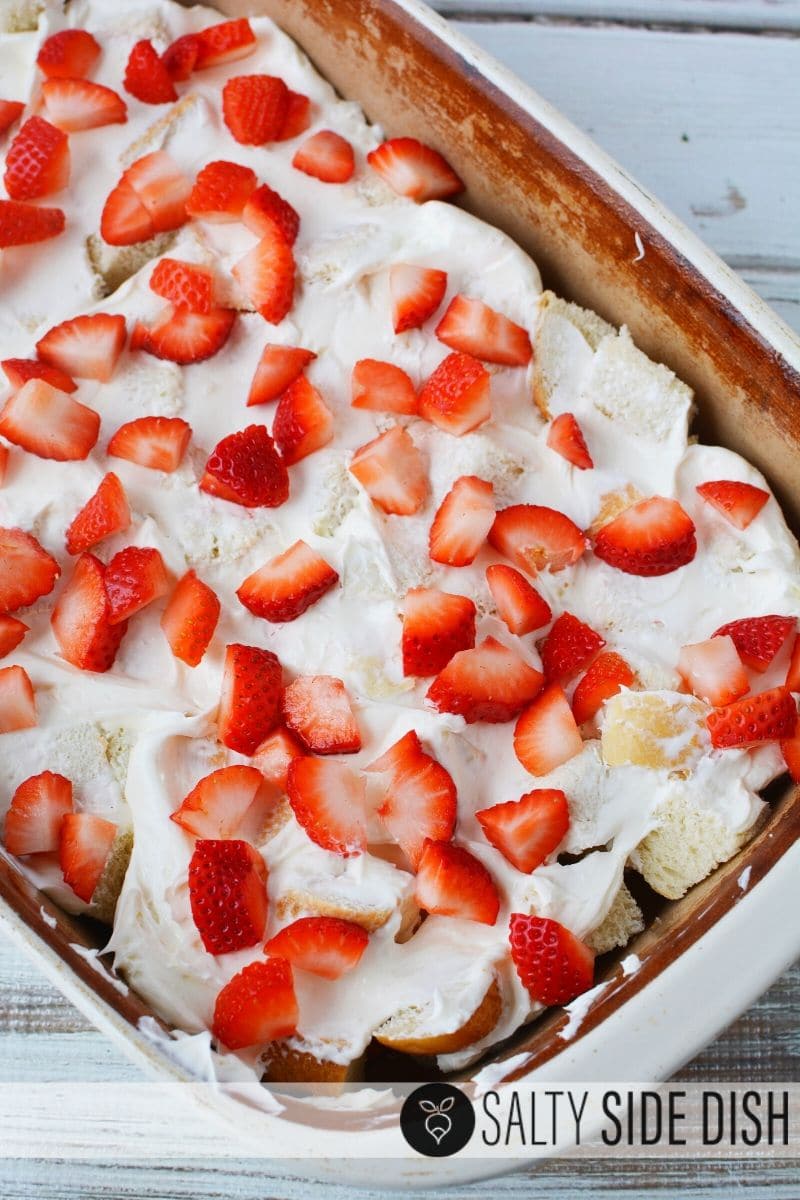 layered strawberries and cream in a casserole dish prior to egg wash