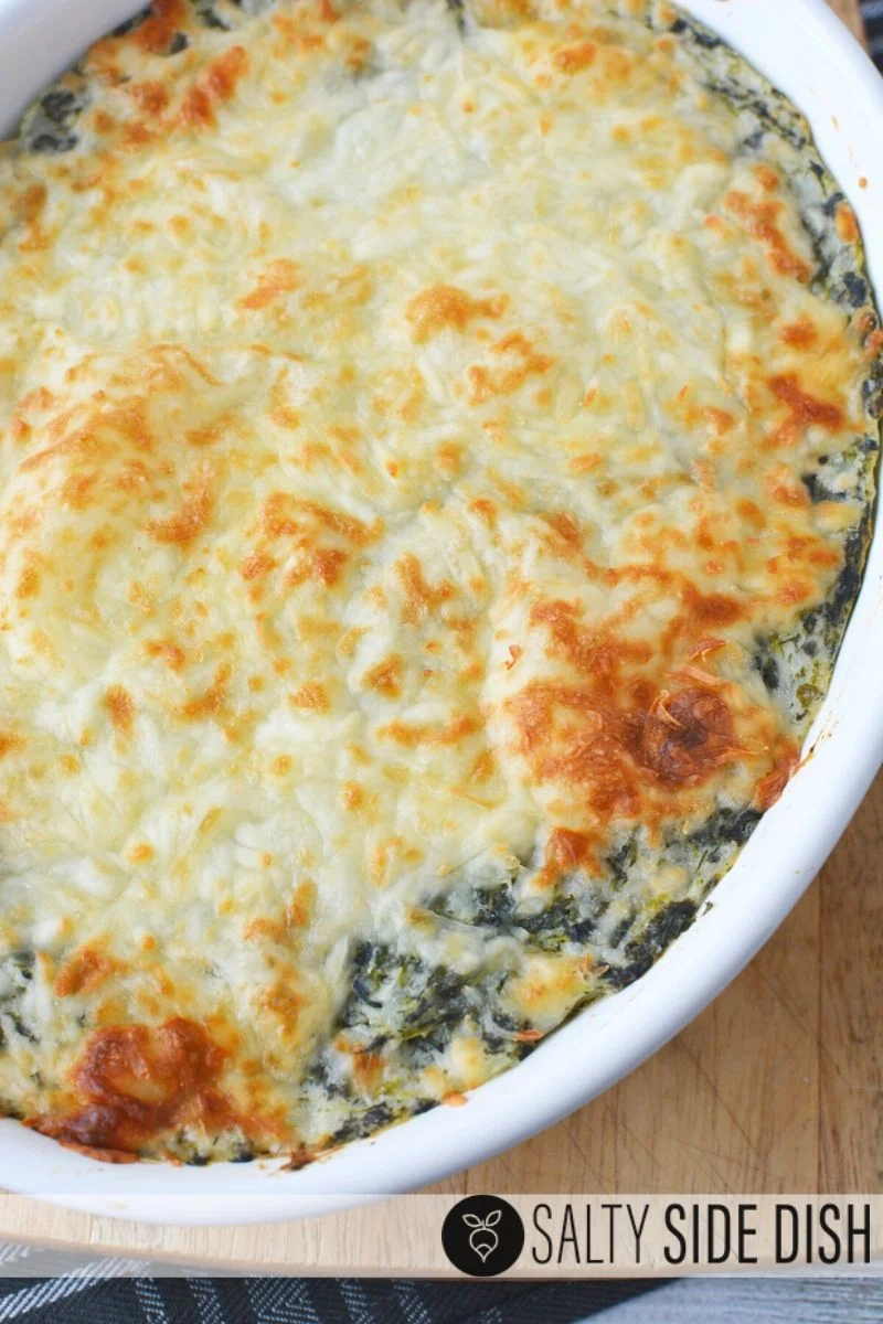 Spinach Mashed Potatoes with melted mozzarella slightly browned already oven baked and ready to serve as a perfect side dish inside a white casserole dish